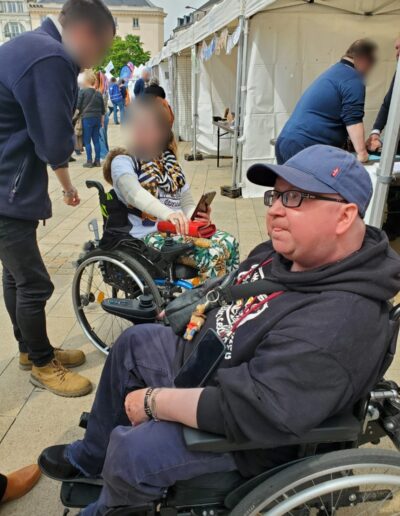 Journée de la Solidarité 2025 : participant en fauteuil roulant au milieu du village associatif