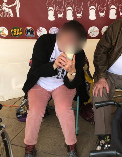 Journée de la Solidarité 2025 : participante riant devant la banderole de la Marche du handicap