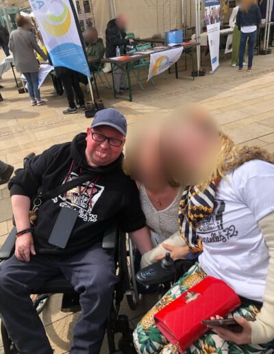 Journée de la Solidarité 2025 : trois participants souriants, dont deux en fauteuil roulant