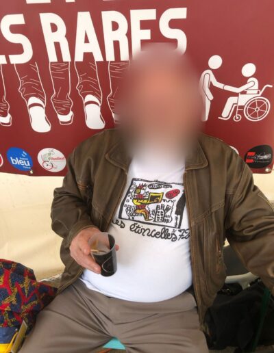 Journée de la Solidarité 2025 : bénévole portant le t-shirt des Étincelles 72 devant la banderole