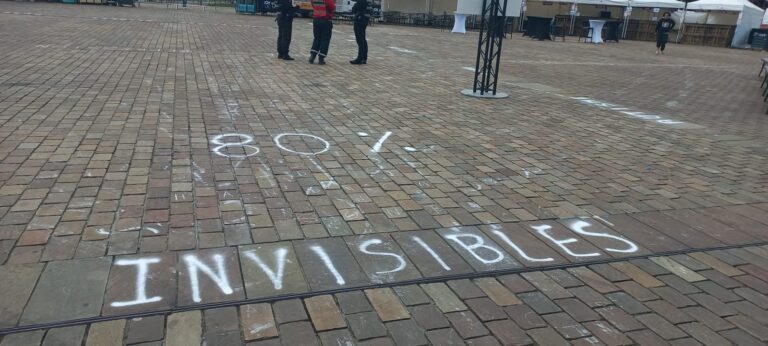 Inscription à la craie « 80 % invisibles » sur les pavés de la place des Jacobins