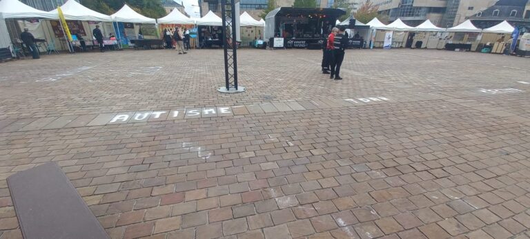 Le mot « Autisme » écrit à la craie au sol pendant le festival
