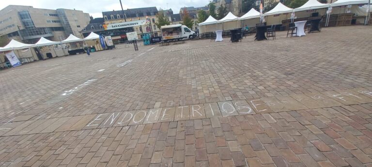 Le mot « Endométriose » écrit à la craie au sol pendant le festival